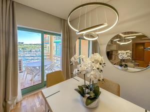 阿尔布费拉Luxury 1 Bedroom Apartment, Marina de Albufeira3的用餐室,配有花瓶桌子