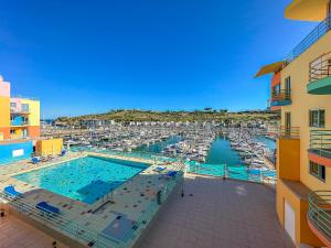 阿尔布费拉Luxury 1 Bedroom Apartment, Marina de Albufeira3的一个带码头的大型游泳池,码头上设有船只