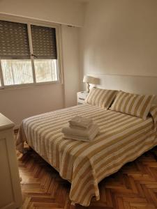 布宜诺斯艾利斯Recoleta Time的一间卧室配有一张床,上面有两条毛巾