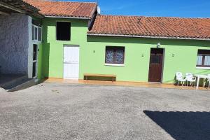 比利亚维西奥萨Casa Verde.的一座带椅子和前面长凳的绿色房子