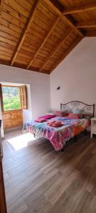 埃尔米瓜Casa Rural Antigua Escuela II的一间设有一张床铺的卧室,位于一个拥有木制天花板的房间