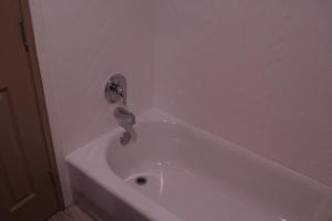阿兰瑟斯港阿兰萨斯港美洲最佳价值旅馆的浴室内设有带水龙头的白色浴缸