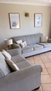埃尔利海滩托斯卡纳乡村酒店的客厅配有灰色的沙发和桌子