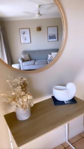埃尔利海滩托斯卡纳乡村酒店的客厅配有镜子和鲜花桌