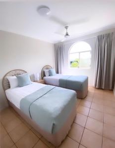 埃尔利海滩托斯卡纳乡村酒店的酒店客房设有两张床和窗户。