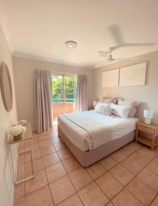 埃尔利海滩托斯卡纳乡村酒店的一间卧室设有一张床和一个大窗户