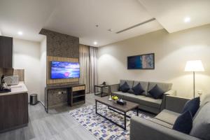 阿可贺巴Enala Hotel - Al Khobar的带沙发和电视的客厅