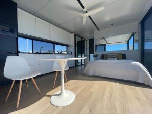 努萨角oasis noosa - luxury floating eco villas的卧室配有床和白色的桌椅