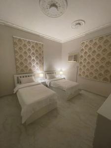 阿哈达فيلا ميسرة الهدا的一间卧室设有两张床,天花板上设有两个灯。