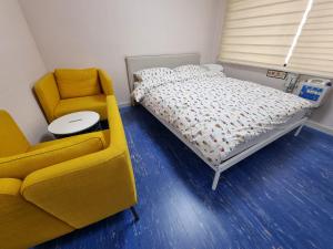 仁川市Bluehum Guest house的一间卧室配有一张床、一张沙发和一把椅子