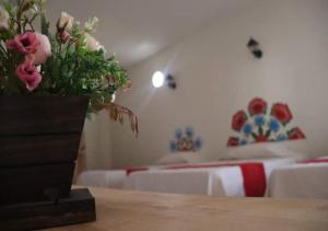 TararameoMia Bonita Hotel Boutique的一间卧室设有两张床,一张桌子上放着花瓶