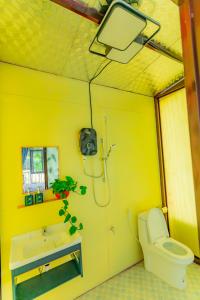 Gia NghĩaPhuong Nam Gia Trang Farmstay的黄色的浴室设有卫生间和水槽