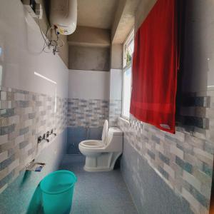 SombāriLali Gurash Homestay - Okhrey的一间带卫生间和红色毛巾的浴室