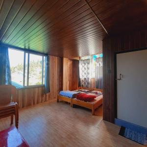 SombāriLali Gurash Homestay - Okhrey的木制客房内的一间卧室,配有一张床