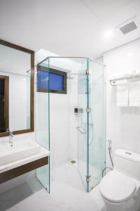 岘港Minh Quan Hotel - Da Nang Center By HOS的一间带玻璃淋浴和卫生间的浴室
