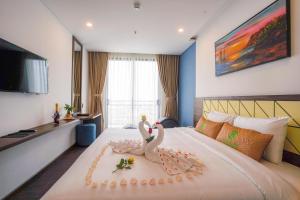 岘港Minh Quan Hotel - Da Nang Center By HOS的酒店客房,床上有两只天鹅