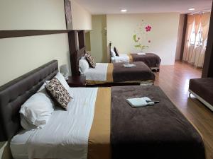巴尼奥斯Hotel Casa Santa Lucía的酒店客房,设有两张床和一张沙发