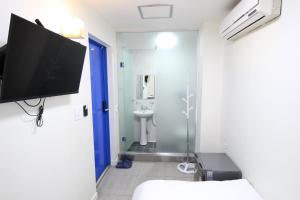 首尔Stay in Blue的一间带壁挂式电视和卫生间的浴室