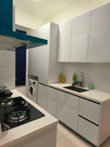 乔治市Beacon Executive Suites - By IZ的厨房配有白色橱柜和炉灶烤箱。
