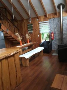 普孔Agradable Cabaña inserta en bosque nativo的客厅配有长凳和桌子