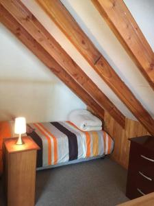 普孔Agradable Cabaña inserta en bosque nativo的一间小卧室,阁楼上配有一张床