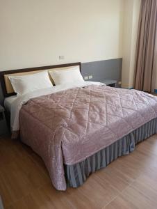 北竿乐活海景民宿的卧室配有一张带白色床单和枕头的大床。
