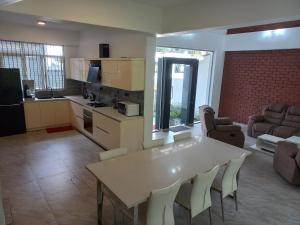尼甘布The Anchorage Villa - Negombo的厨房以及带白色桌椅的起居室。