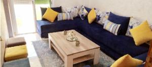 Tafzaمسكن الراحة的客厅配有蓝色沙发及茶几