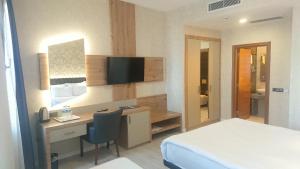 安塔利亚Isnova Hotel Airport的酒店客房设有一张桌子、一张床和一间卧室。