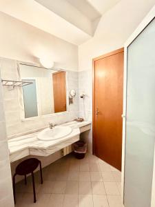 菲乌吉Albergo Ristorante Belsito的一间带水槽、镜子和凳子的浴室