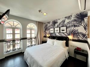 新加坡The Snooze Hotel Marine Parade的一间卧室配有一张白色大床,铺有热带壁纸