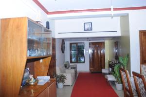 马迪凯里Misty Retreat (Pragati House)的走廊上设有铺有红地毯的起居室