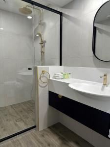 土乌巴三叶草酒店的白色的浴室设有水槽和淋浴。