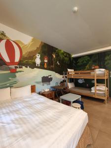 鱼池乡瑞居渡假饭店的卧室配有一张大床,墙上挂有绘画作品