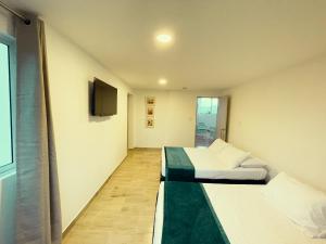 圣罗莎德卡瓦尔Hotel Campestre Villa Mary的客房设有两张床和一台平面电视。