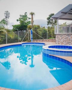圣罗莎德卡瓦尔Hotel Campestre Villa Mary的庭院里的一个蓝色海水游泳池