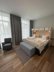 埃姆登法德普特酒店的一间卧室配有一张大床和一把椅子