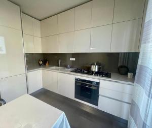 利多迪卡马约雷Villa I tre Cipressi的厨房配有白色橱柜和炉灶烤箱。