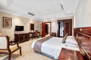 多哈主席酒店的酒店客房配有一张床、一张书桌和一台电视。