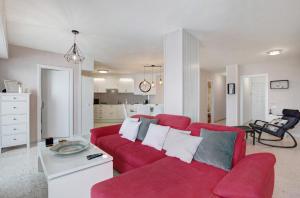 塔科龙特Apartamentos Tamara的一间带红色沙发的客厅和一间厨房