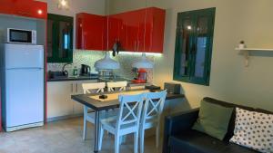 凯法利尼亚岛Katarina Apartments的厨房配有红色橱柜和桌椅