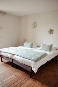 Saint-PorchaireChâteau de La Vallade的白色客房的一张大床,铺有木地板