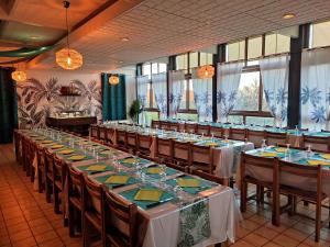 蒂雷纳Kamea Club La Gironie的一个带长桌和椅子的大型宴会厅
