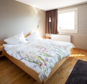 林格瑙Hotel Gasthof Wälderhof的一间卧室配有一张带花卉床罩的大床