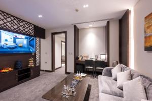 多哈Ramada Encore Doha by Wyndham的带沙发和电视的客厅
