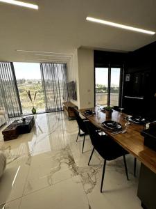 耶路撒冷Stylish and spacious 3BR apartment in the heart of Jerusalem! اهلا وسهلا的客厅配有长木桌子和椅子