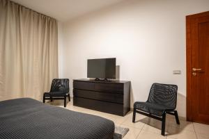 巴里Home Abate Gimma 170的一间卧室配有一张床、两把椅子和电视