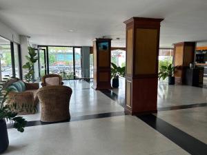 乌汶Bordin Hotel的大厅,在大楼里摆放椅子和植物
