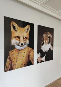 罗塞格Hotel Fuchs & Hase SELF CHECK IN的墙上两幅狐狸和兔子画
