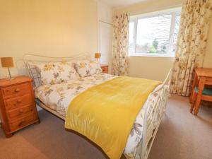 TuxfordCheriton的一间卧室配有一张带黄色棉被的床和窗户